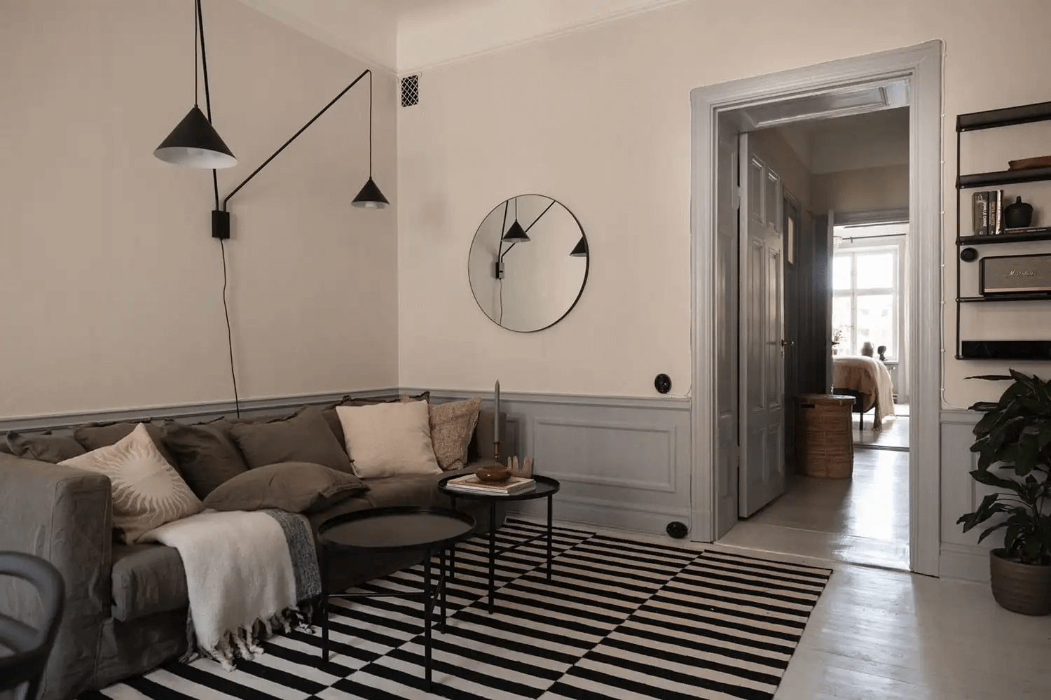 A historic apartment with a light grey kitchen and grey wainscoting