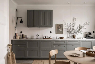 A grey shaker kitchen paired with grey couches and a dark grey bedroom11