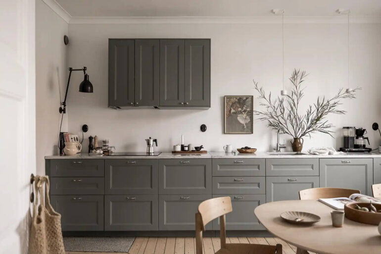 A grey shaker kitchen paired with grey couches and a dark grey bedroom11